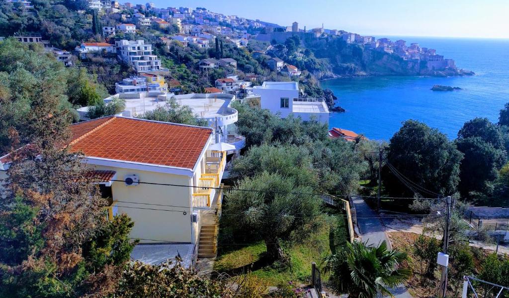 a house on a hill next to the ocean at Apartment Spuza in Ulcinj