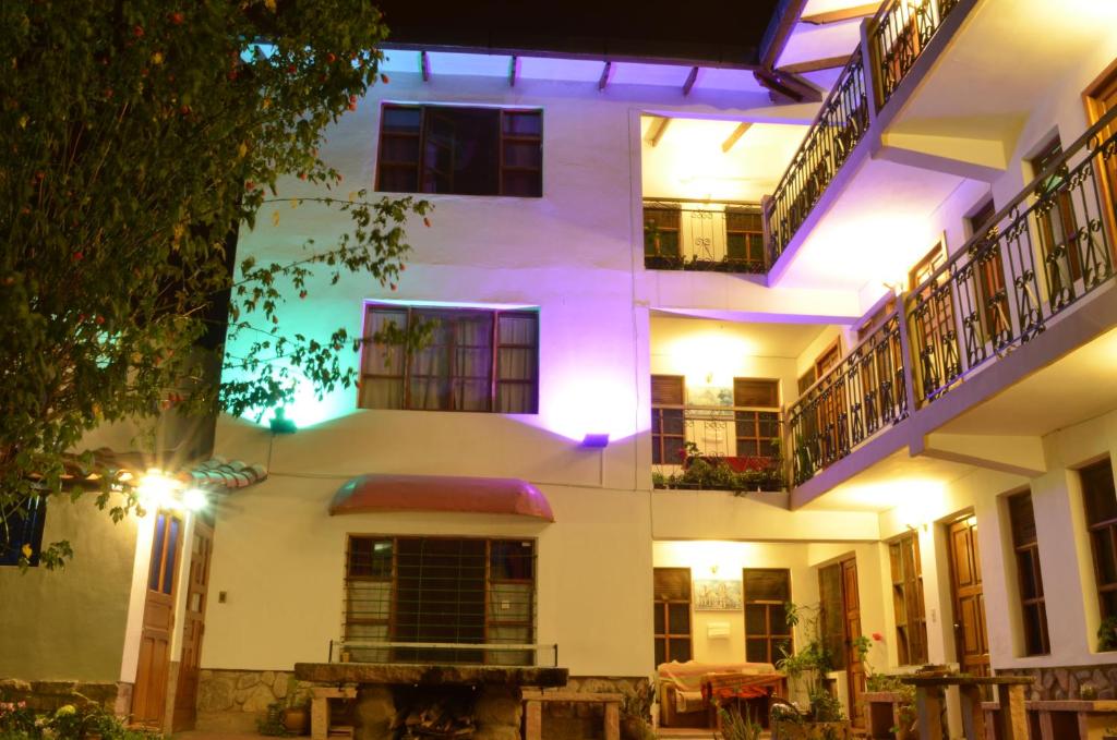 un gran edificio blanco con luces moradas. en Hostal Pachamama en Sucre