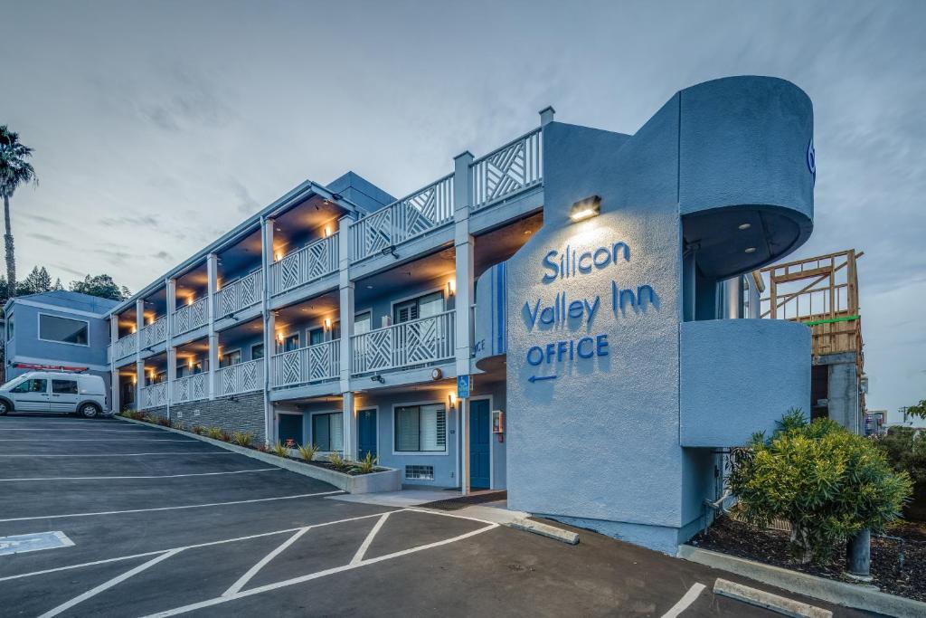 a exterior view of a hotel with a parking lot at Silicon Valley Inn in Belmont
