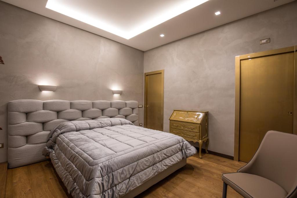 a bedroom with a large bed and a table at Civico Cinque Home Luxury Apartment in Salerno