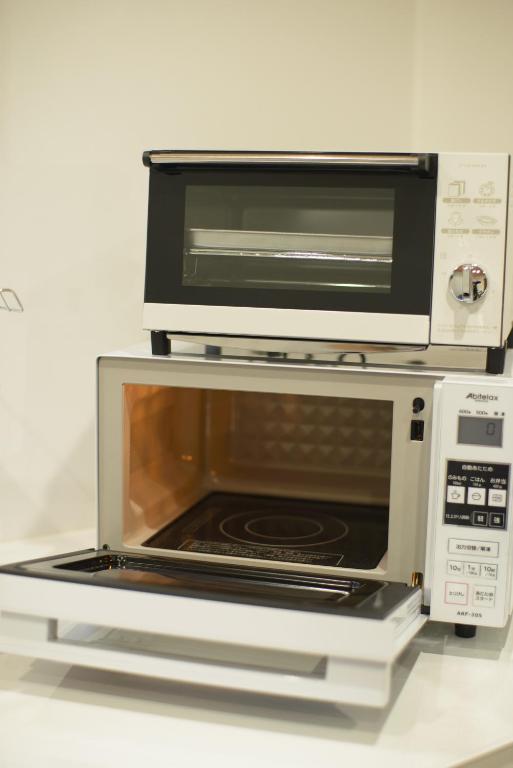 金沢市にあるゲストハウス 金ととの電子レンジの上に座るトースターオーブン
