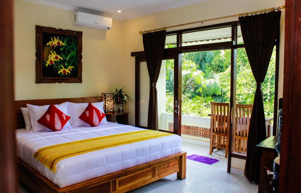 una camera con un letto e una grande finestra di Manwarsa Guest House ad Ubud