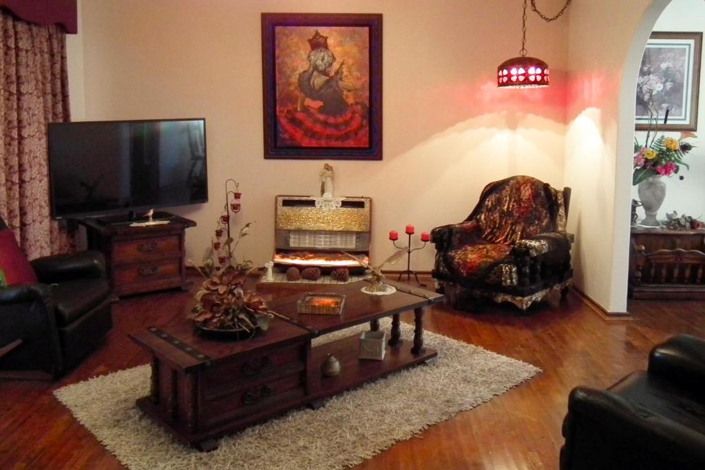 a living room with a tv and a chair and a table at The Spanish Guesthouse, pets considered in Perth