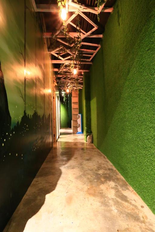 an empty hallway with a green wall and a hallwayngth at Kenting Original Hostel in Kenting