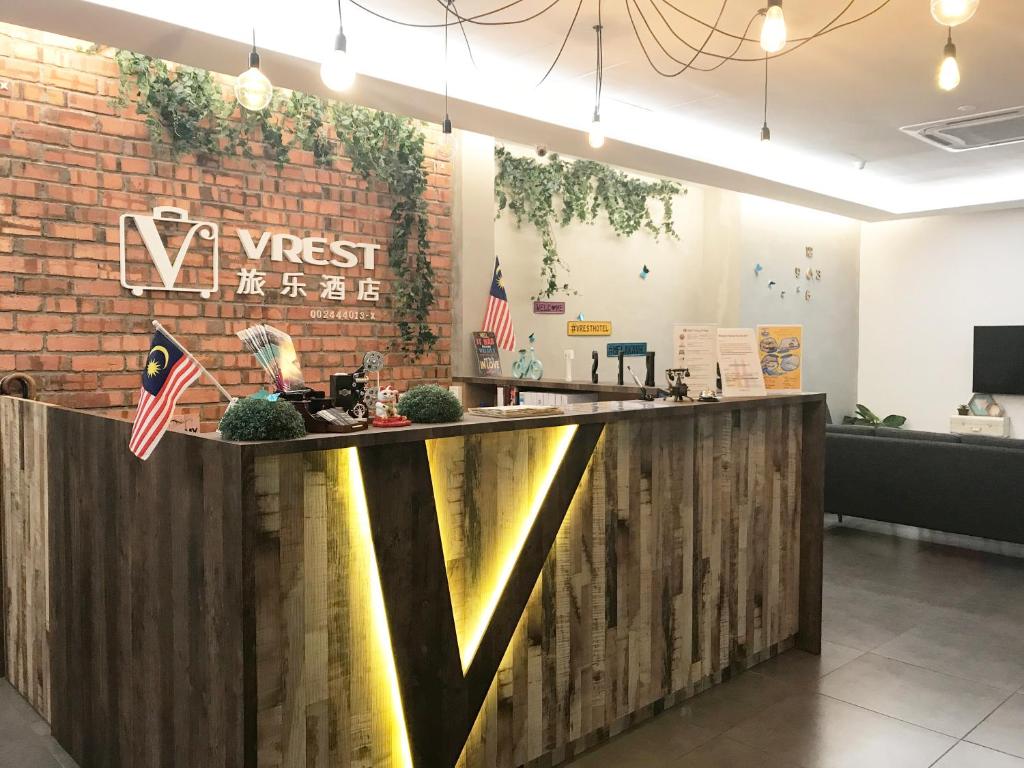a bar in a restaurant with a brick wall at Vrest Hotel in Malacca