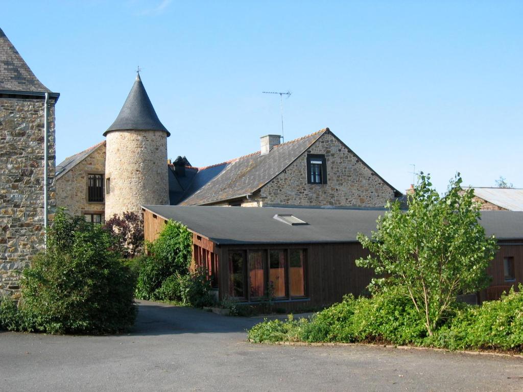 un edificio con dos torretas y un edificio con garaje en Gîtes de la Ferme Auberge de Mésauboin, en Billé
