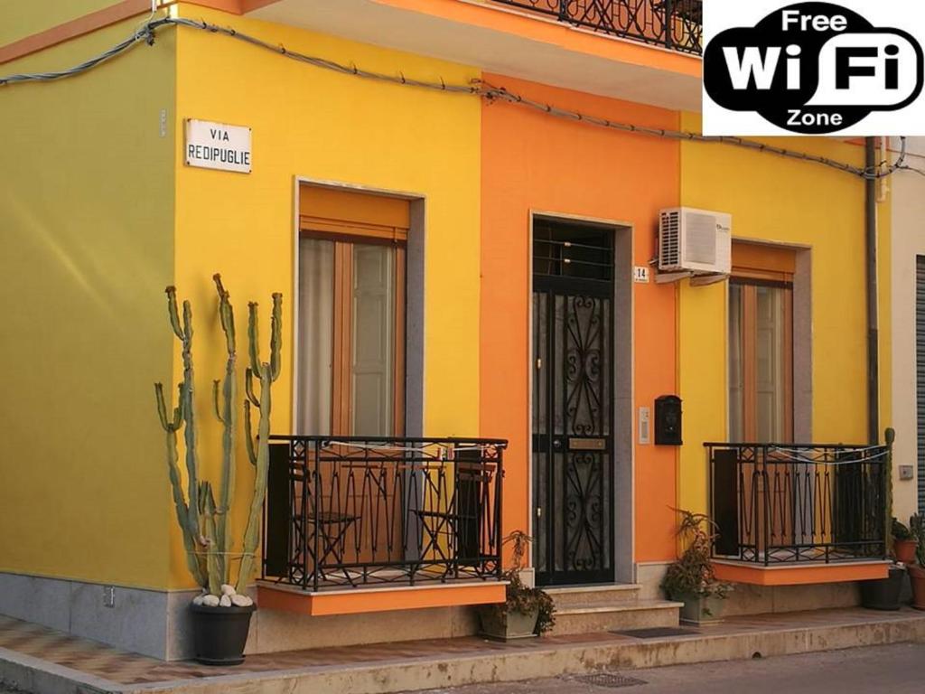 a yellow and orange house with a cactus at Nice House wifi free bici free in Avola