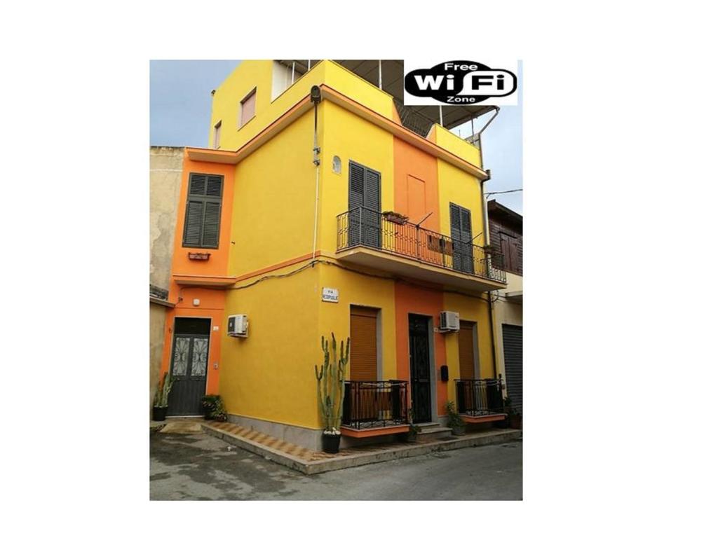 żółto-pomarańczowy dom z balkonem w obiekcie Happy House Wifi Free Bici Free w mieście Avola