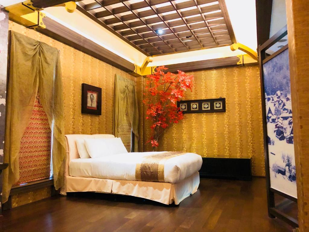 ein Schlafzimmer mit einem Bett in der Ecke eines Zimmers in der Unterkunft Hakodate Motel in Kaohsiung