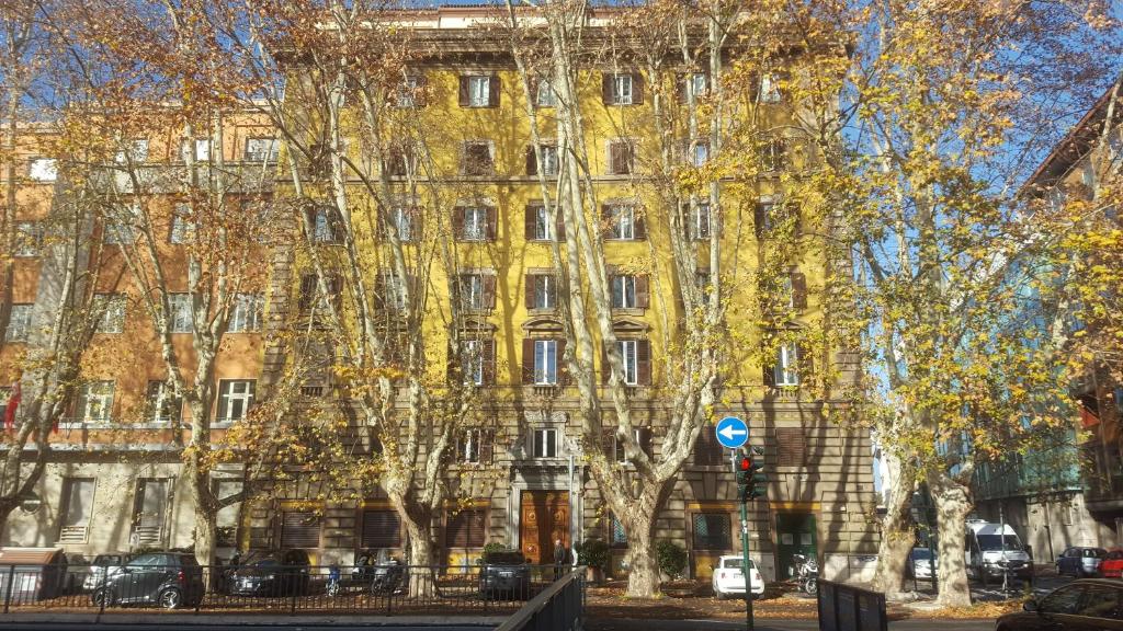 un edificio giallo con alberi di fronte di Via Veneto Luxury Suites a Roma