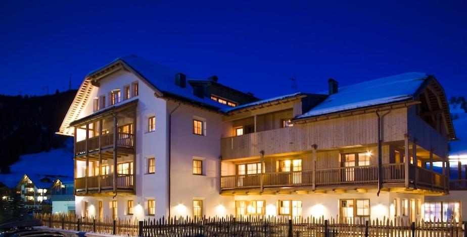 a large building at night with its lights on at Nei Y Suredl NeveSole in Corvara in Badia
