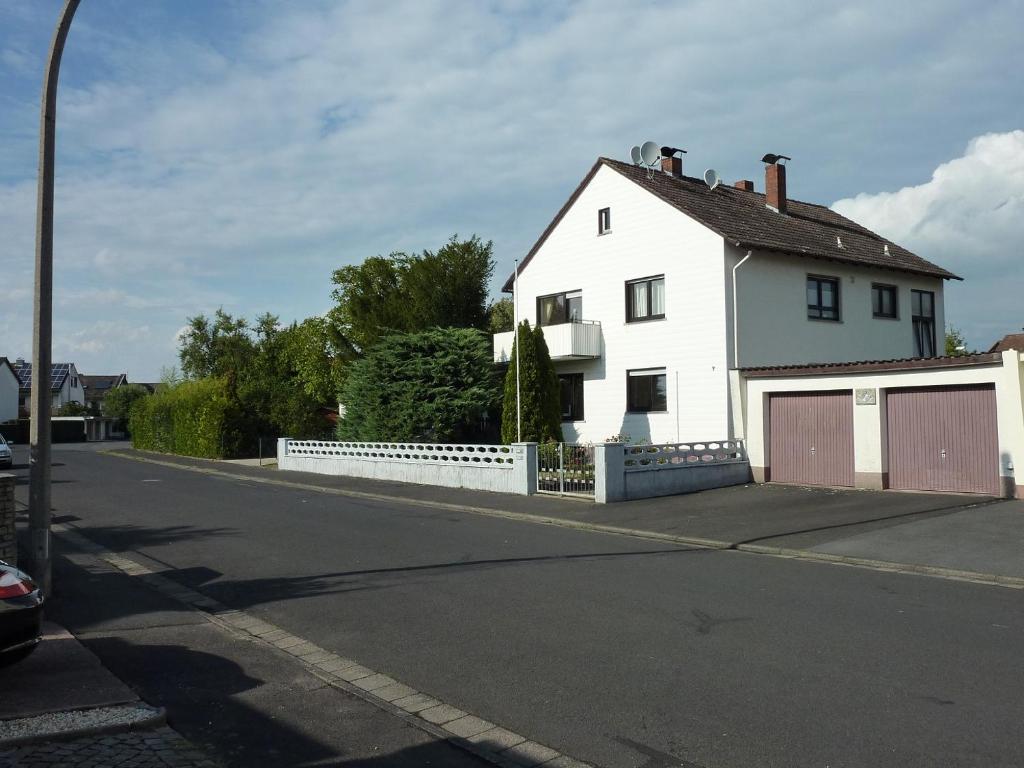 Ein weißes Haus an der Seite einer Straße in der Unterkunft Ferienwohnung Landwehr in Großostheim