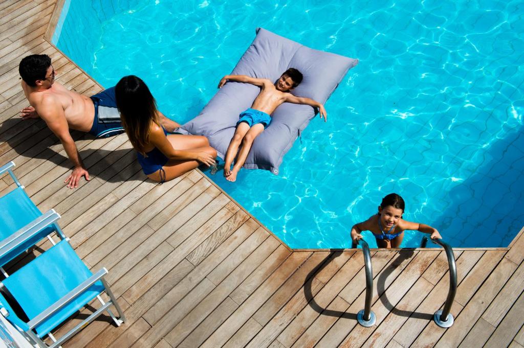 a group of people laying in a swimming pool at Hotel Antibes in Riccione