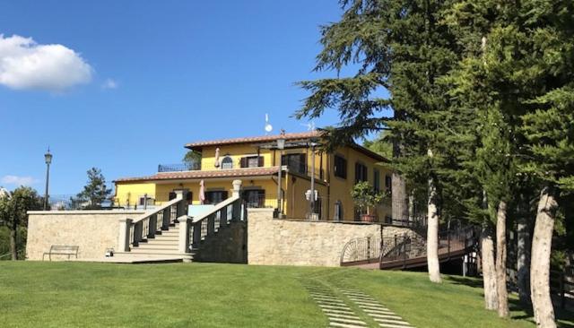 una grande casa gialla con scale in un cortile di Villa Ghiandai ad Arezzo