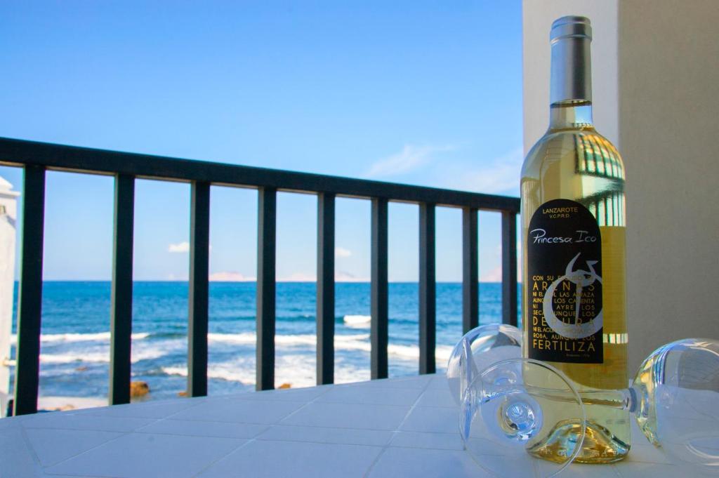 カレタ・デ・ファマラにあるSeaview Famara 1の海の景色を望むテーブルに座ったワイン1本