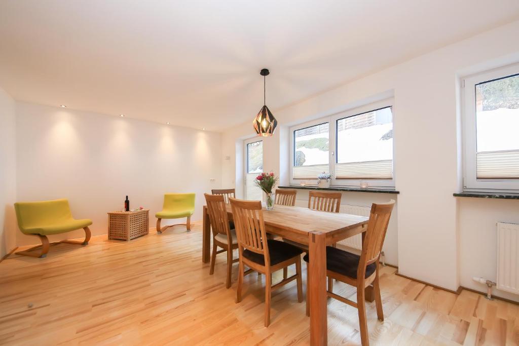 a dining room with a wooden table and chairs at Ferienwohnungen Wartbichler in Lofer