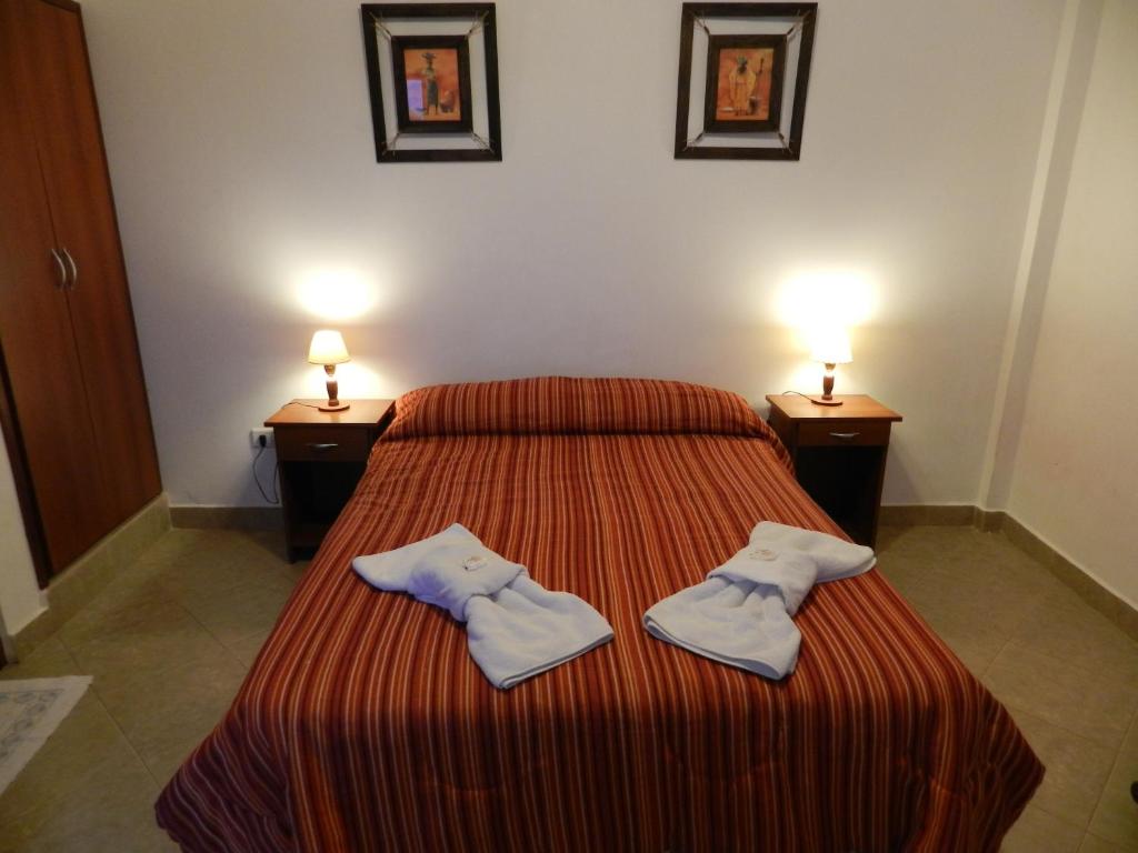 1 dormitorio con 1 cama con 2 toallas en Hotel Buenos Aires en Salta