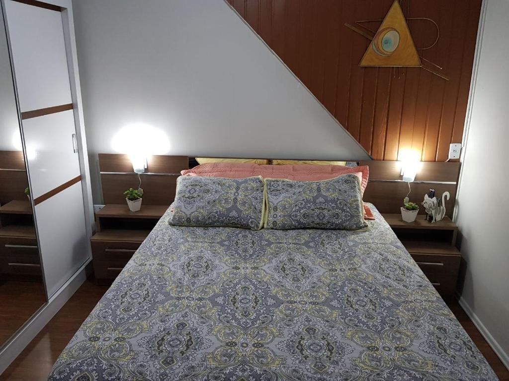 une chambre avec un grand lit avec deux tables de nuit dans l'établissement Apartamento no Centro de Canela, à Canela