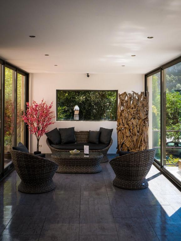 a living room with a couch and chairs and windows at Le Belvedere in Vallon-Pont-dʼArc