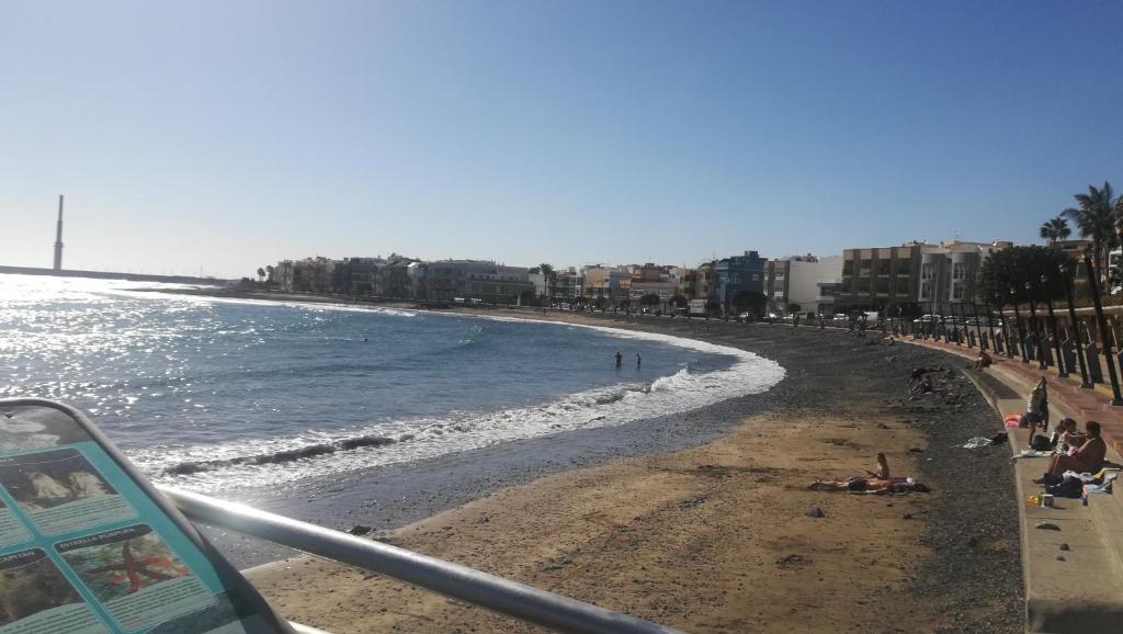 vista su una spiaggia con persone e sull'oceano di Apartamento Quintana a Arinaga