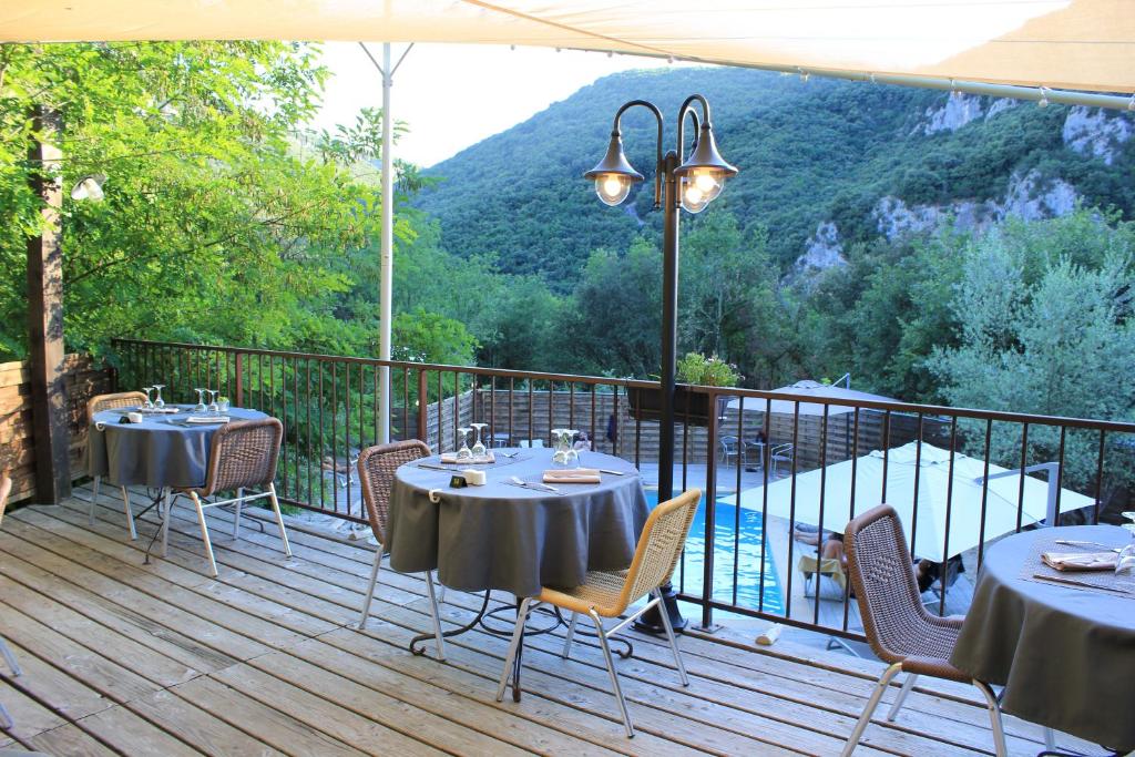 two tables and chairs on a deck with a view at Le Belvedere in Vallon-Pont-dʼArc