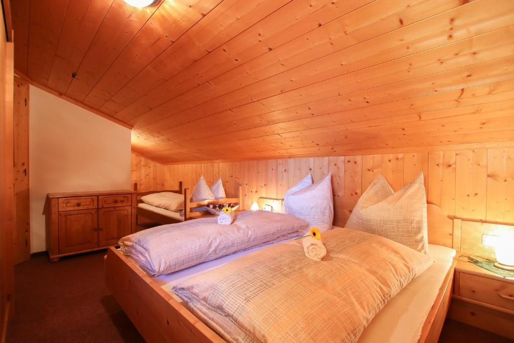 a bedroom with a large bed in a wooden room at Haus Eder in Saalfelden am Steinernen Meer