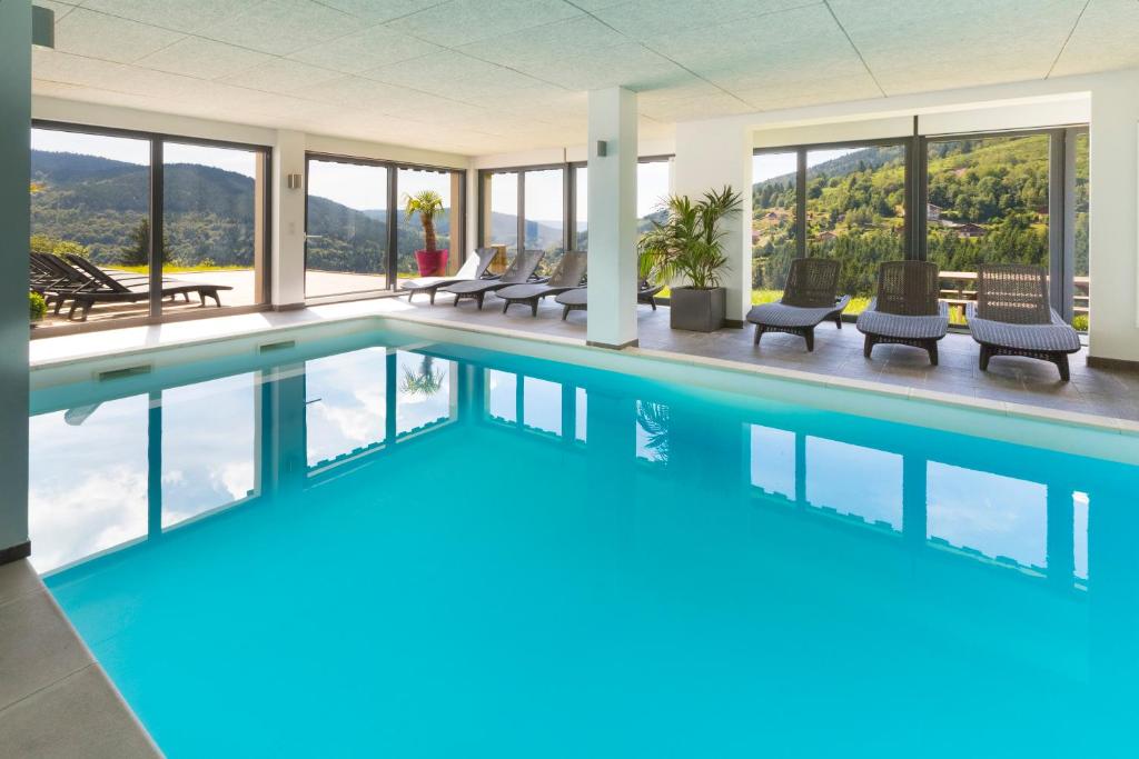 - une piscine avec vue sur un bâtiment dans l'établissement Chalet Bellevue, à Ventron
