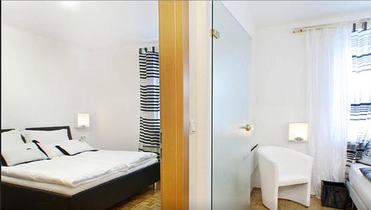 Design Home 1020 في فيينا: غرفة نوم مع سرير وغرفة مع نافذة