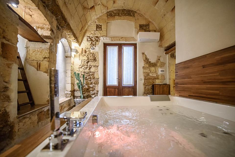 un ampio bagno con una grande vasca in una stanza di Sacratum B&B Suite Spa a Mesagne