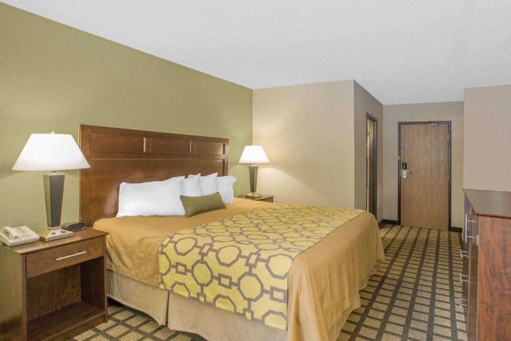 a hotel room with a large bed and a night stand at Park Inn by Radisson, Ames in Ames