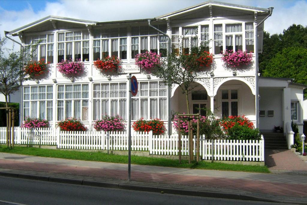 une maison blanche avec des fleurs et une clôture dans l'établissement Villa Wilhelmshöhe by Rujana, à Binz