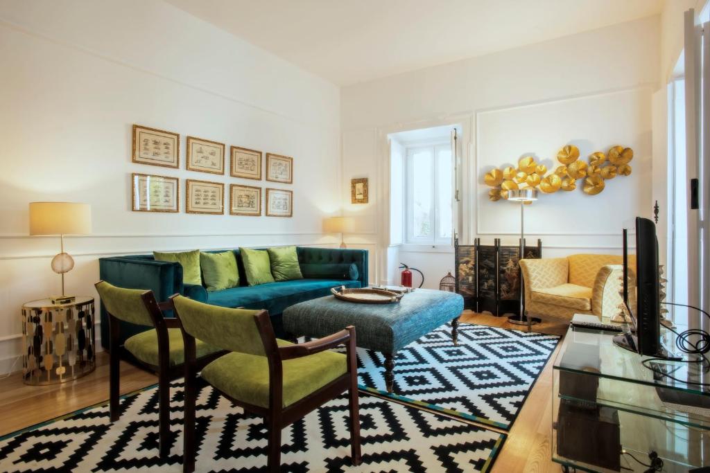 uma sala de estar com um sofá azul e cadeiras em Portas De São Bento Apartments em Lisboa