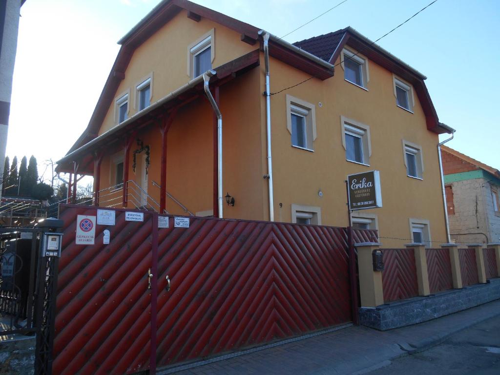 ein Haus mit einem roten Zaun davor in der Unterkunft Erika Vendégház in Eger