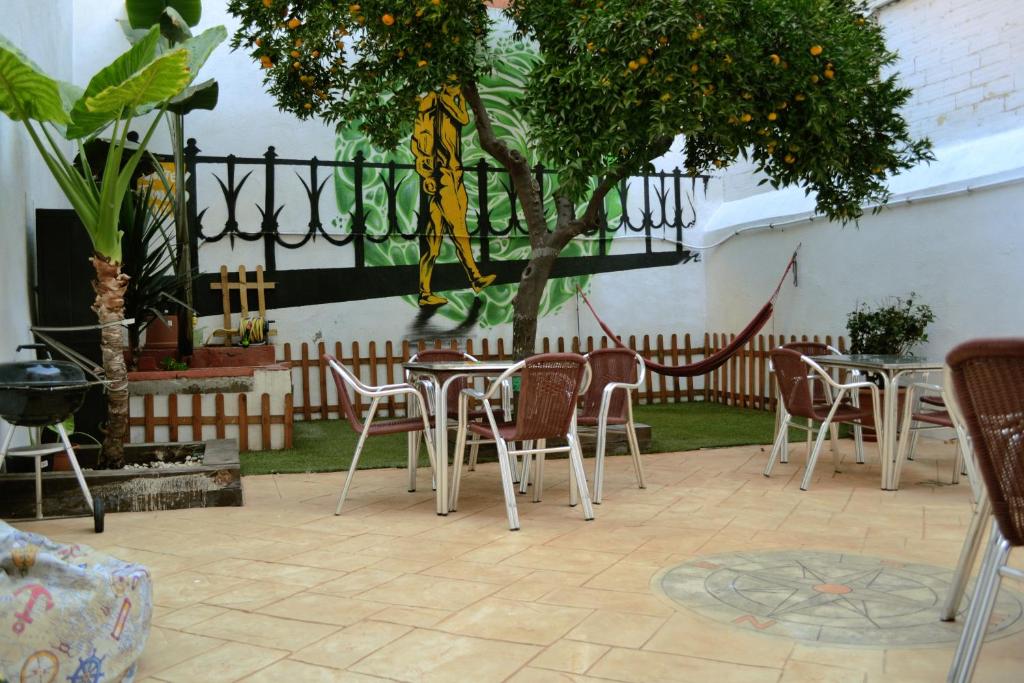 a patio area with tables, chairs and umbrellas at Tarragona Hostel in Tarragona