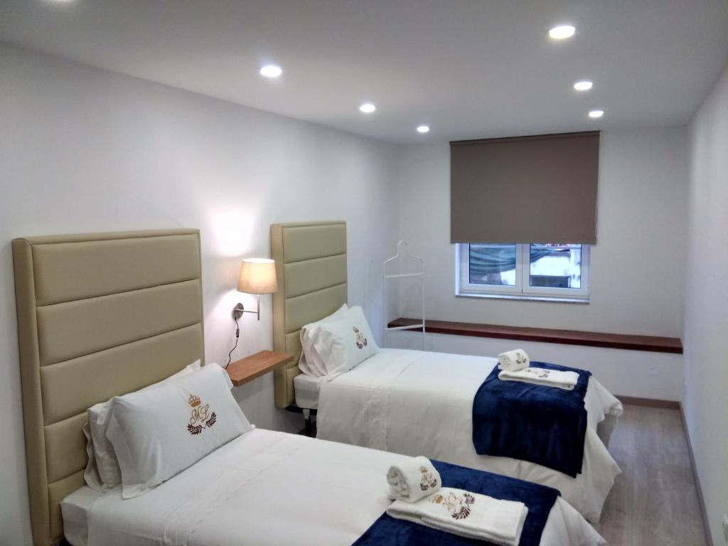 Habitación de hotel con 2 camas y ventana en ML Apartments Aliados, en Oporto