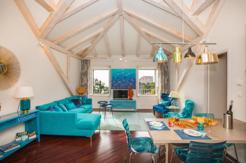 a living room with blue furniture and a table at Villa Ani apartment Ariel in Dubrovnik