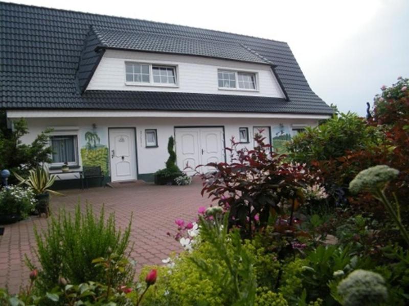 a white house with white doors and a courtyard at Ferienhaus mit Seeblick in Baabe