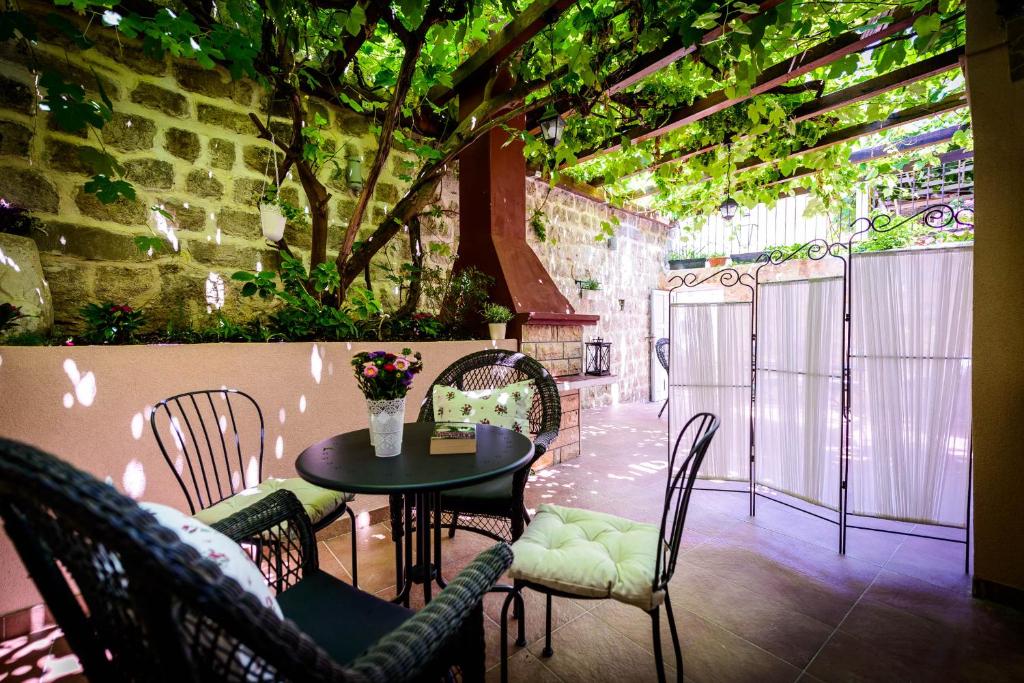 a table and chairs in a room with a tree at Leona Apartments in Dubrovnik