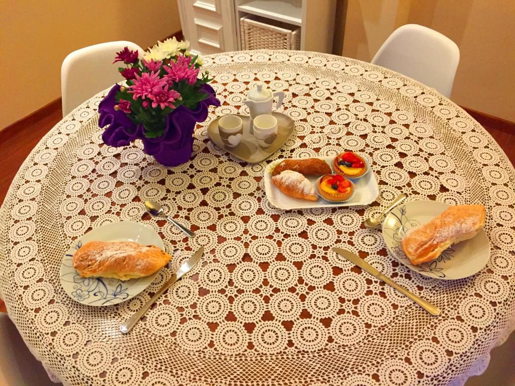 un tavolo con piatti di cibo e un vaso di fiori di La Casa Del Pellegrino VT a Viterbo