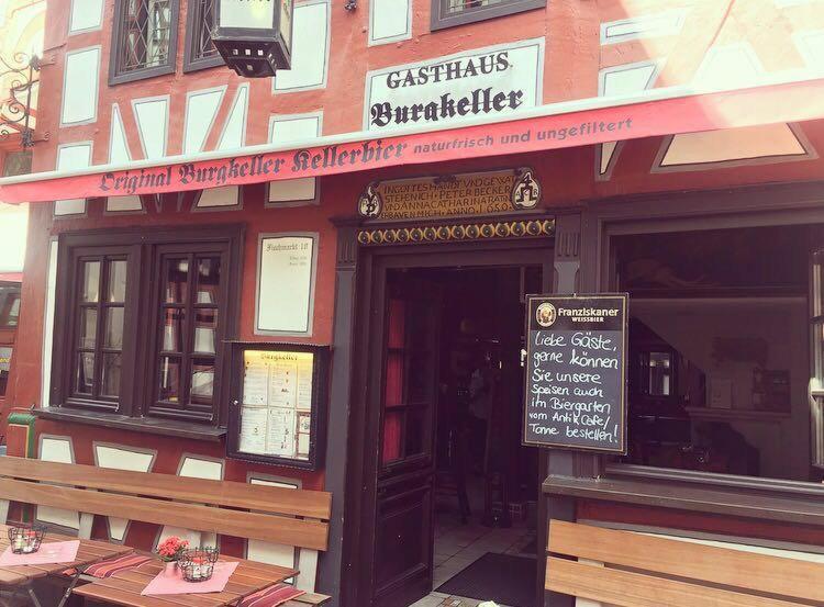 un restaurant avec un panneau en face d'un bâtiment dans l'établissement Gasthaus Burgkeller, à Limburg an der Lahn