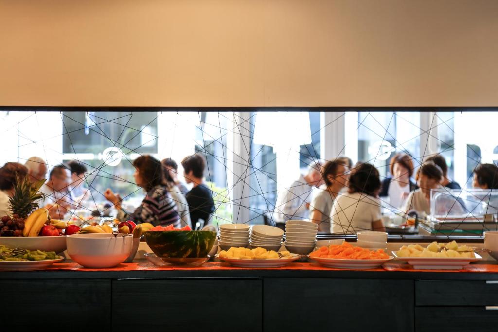 a group of people standing behind a counter with food at Hotel Praia in Nazaré