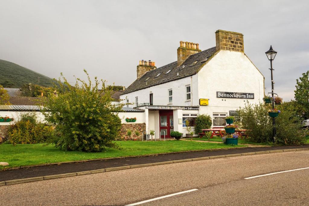 a white building on the side of a road at Bannockburn Inn in Helmsdale