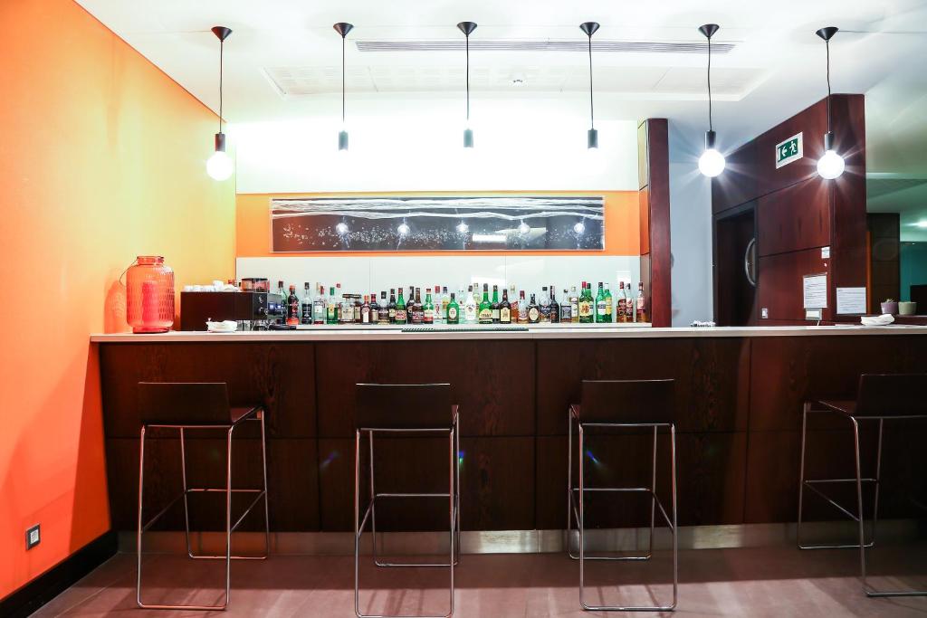a bar in a restaurant with bar stools at Hotel Praia in Nazaré