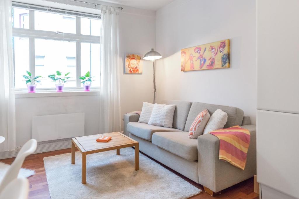 a living room with a couch and a table at Aalesund Apartments - Near Harbour in Ålesund