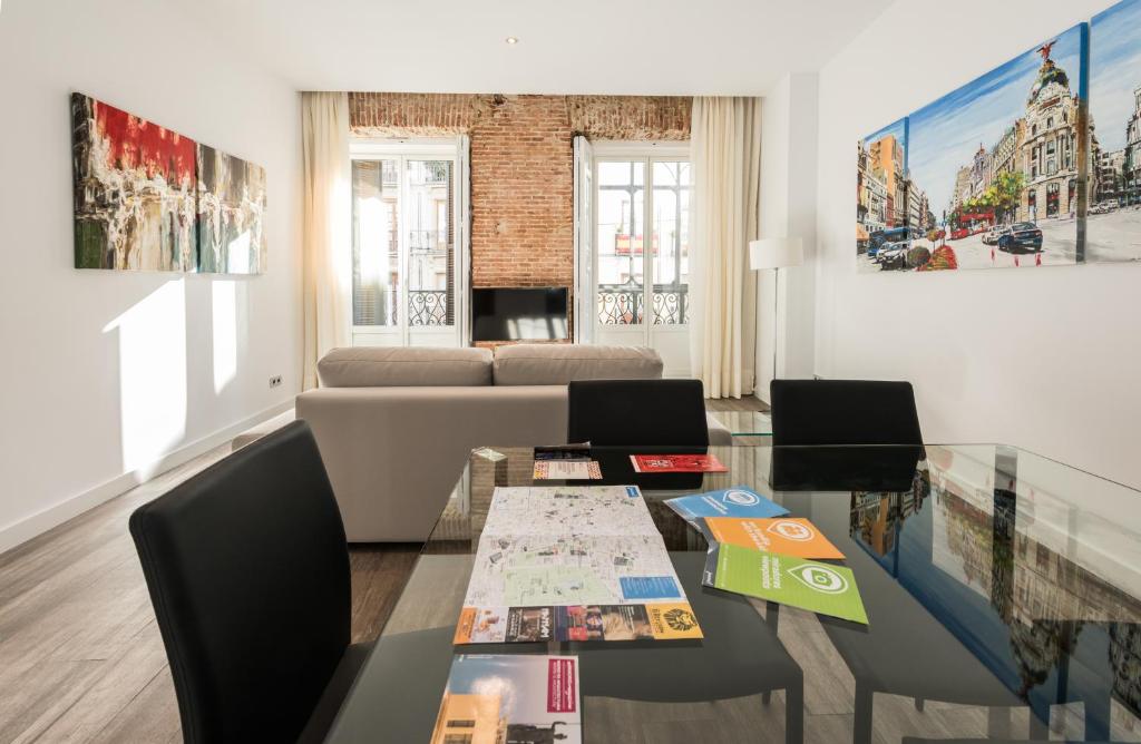 a living room with a glass table and chairs at Puerta Del Sol City Center II in Madrid