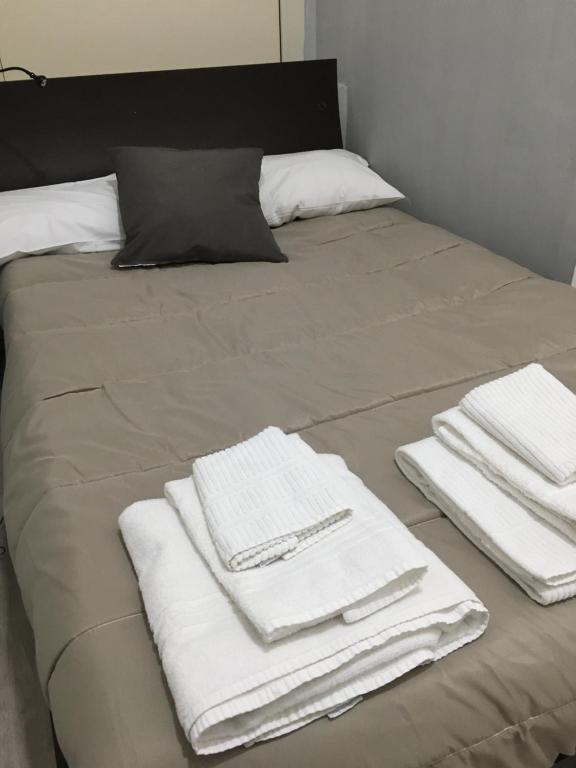 Una cama con toallas blancas encima. en Almayer Noemi, en Gaeta