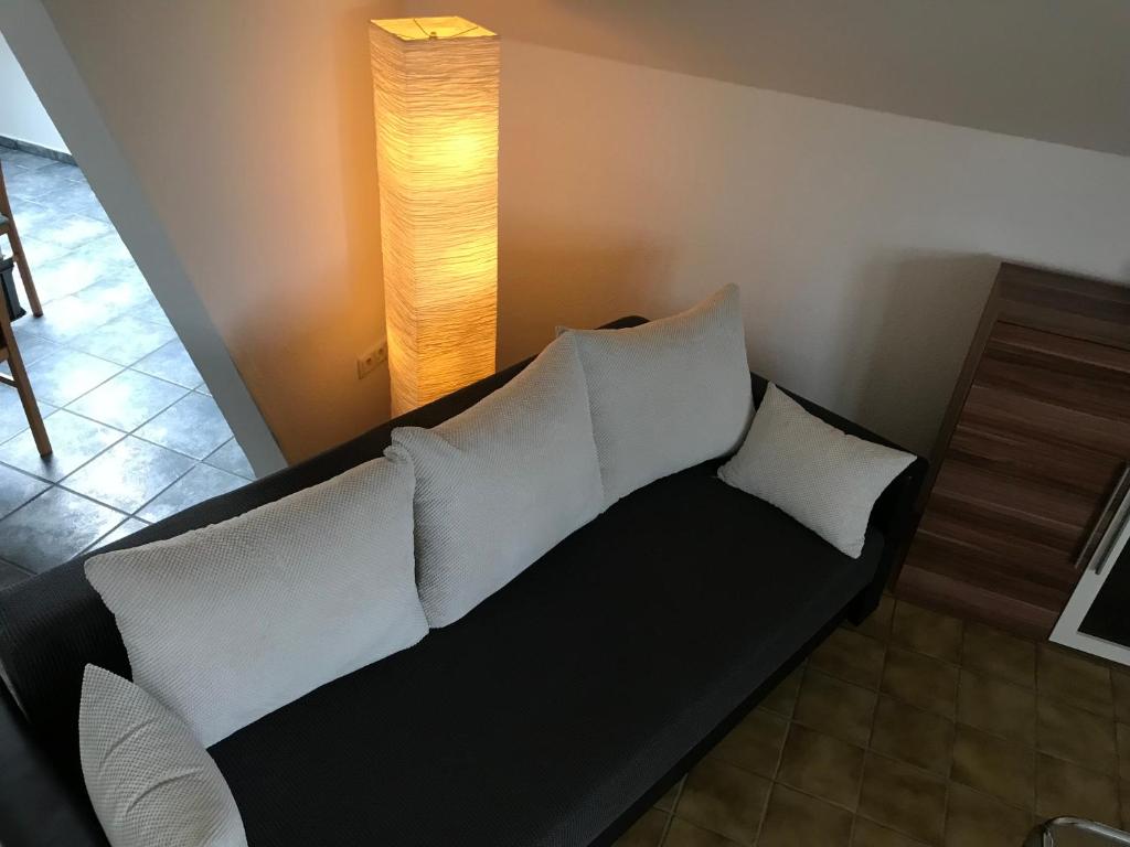 a black couch with white pillows in a room at Apartment Am Sudbach in Löhne