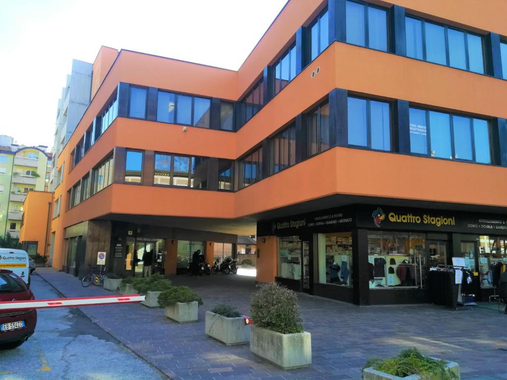 pomarańczowy budynek z samochodem zaparkowanym przed nim w obiekcie Centro Piave Apartment w Trydencie