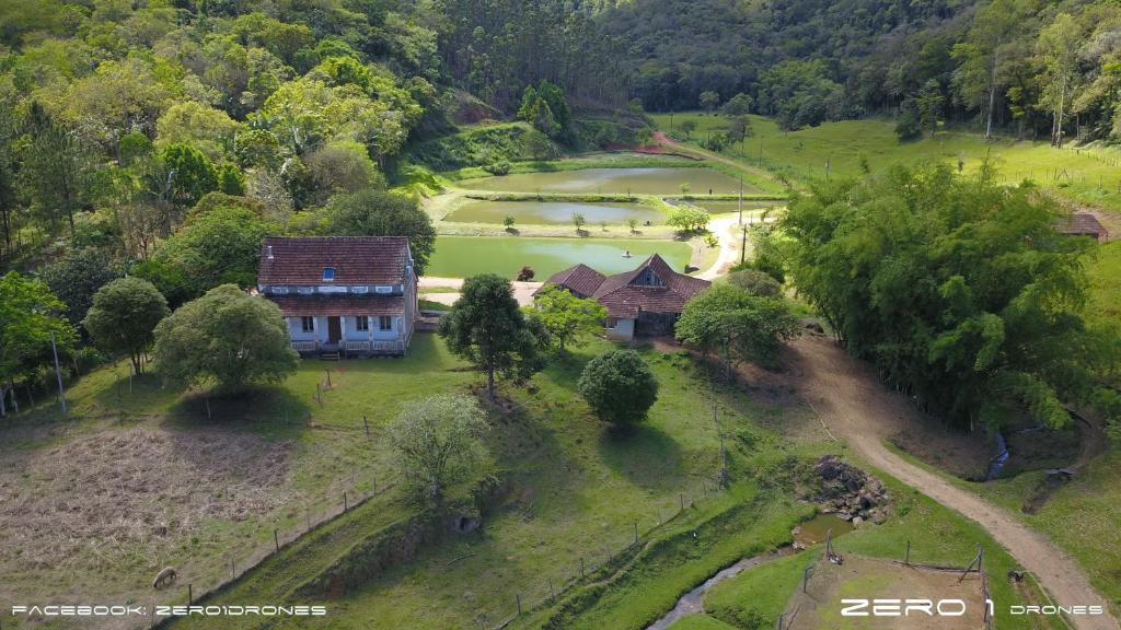 - une vue aérienne sur une maison et un lac dans l'établissement Casa de Campo,Sítio,Vale Europeu-SC, à Rio dos Cedros