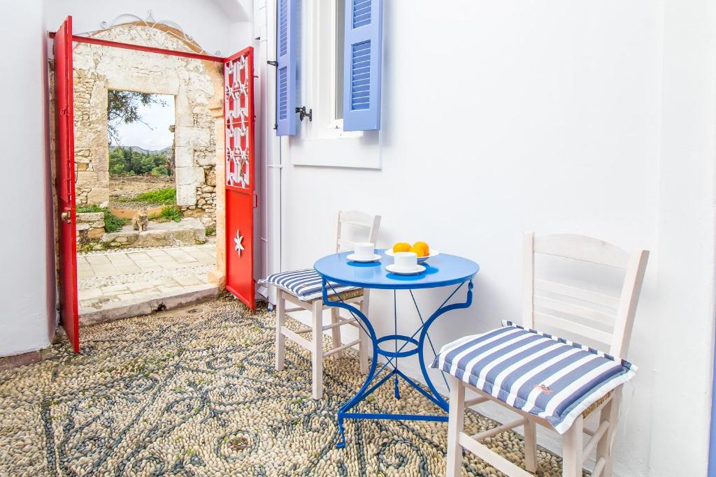 a blue table and two chairs and a red door at The red door in Koskinou in Koskinou